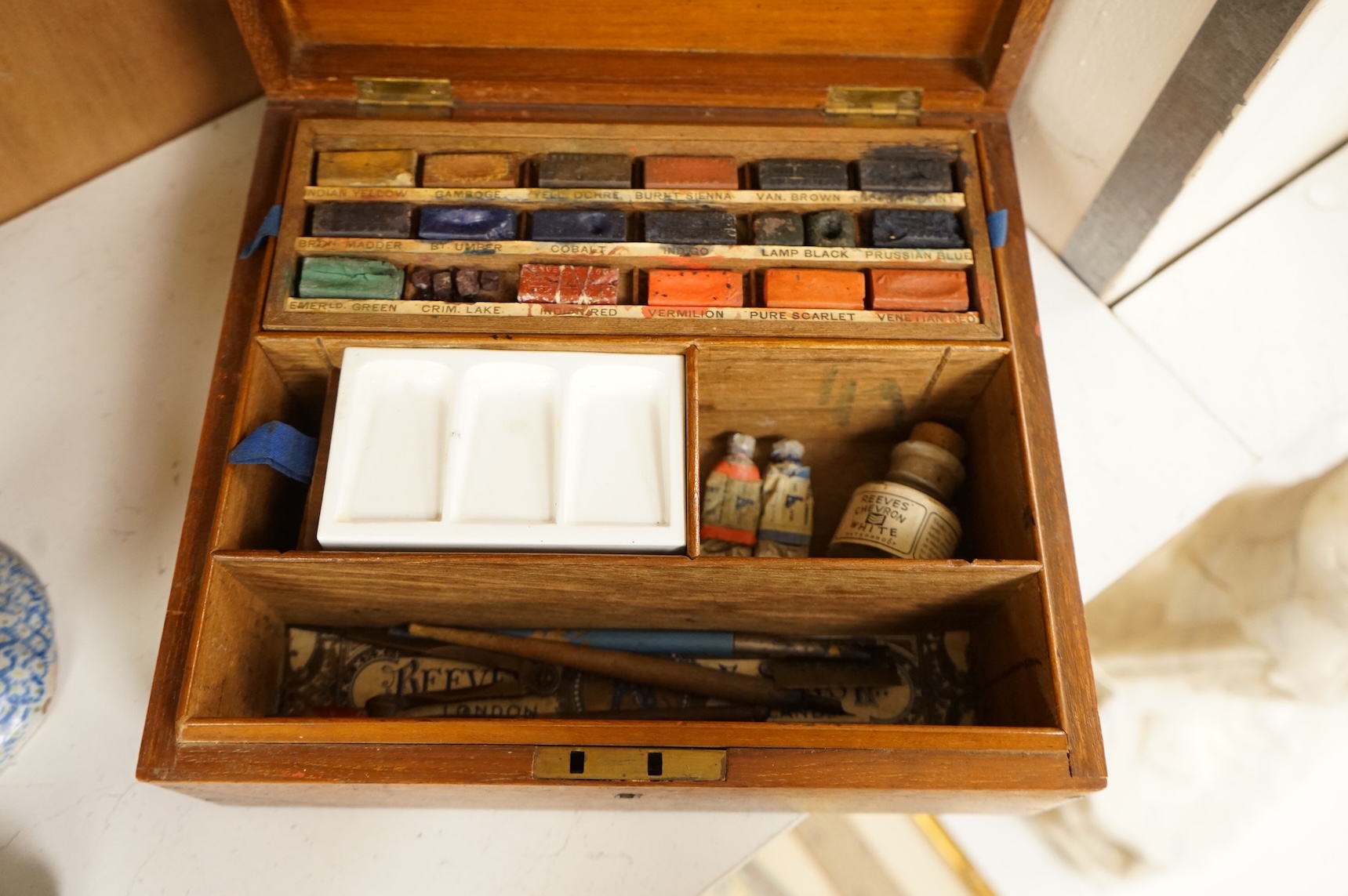 A 20th century Reeves and Sons Ltd artists box with ceramic palette and the remains of paint, 25cm wide